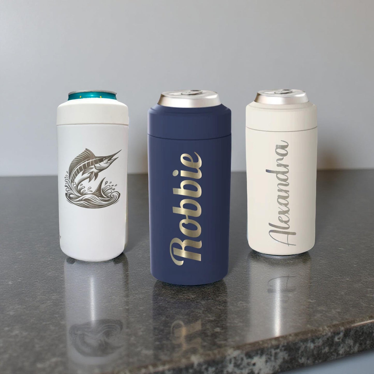 Three personalized can coolers on a gray surface with a plain background