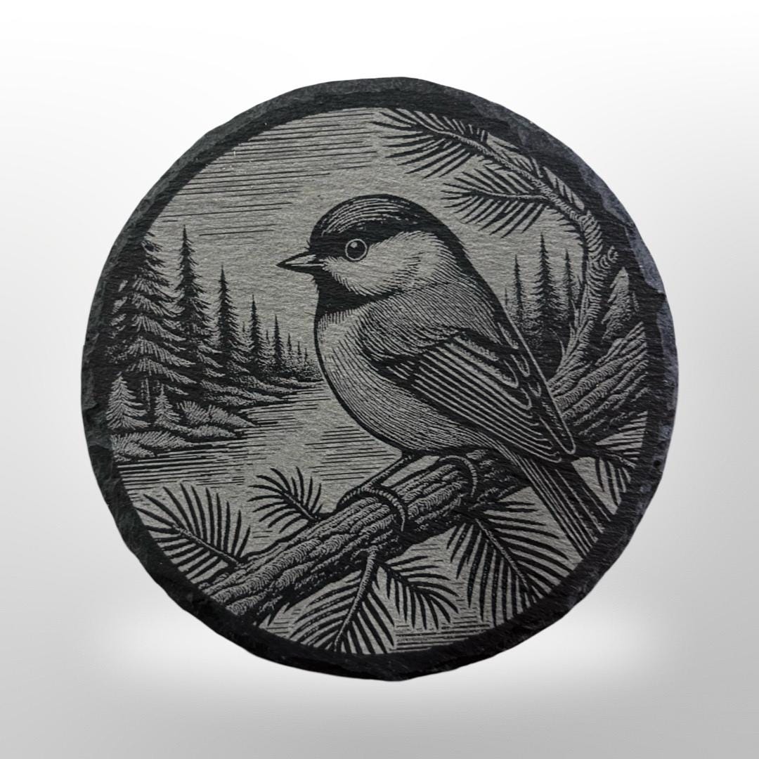 round slate coaster with a chickadee bird engraved onto it